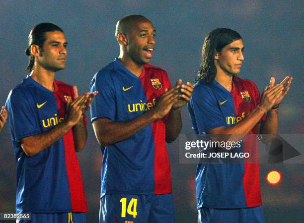 Barcelona's Mexican Rafa Marquez , French striker Thierry Henry and Uruguayan Martin Caceres applaud during an official presentation in their 43th...