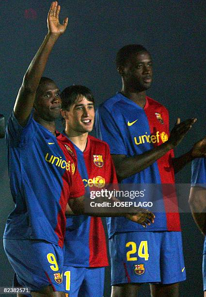 Barcelona's Cameroon 's Samuel Eto'o waves as teammates Bojan Krkic and Ivory Coast ' Yaya Toure applaud during an official presentation in their...