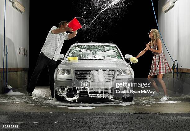 man throwing water at woman while washing car - car splashing water on people stock pictures, royalty-free photos & images