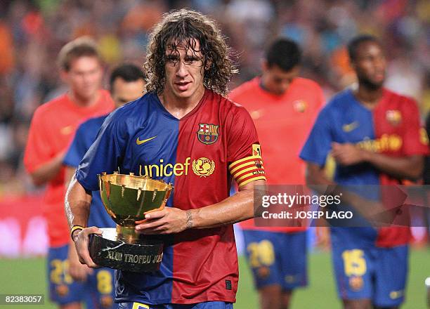 Barcelona's captain Carles Puyol holds his champion trophy in their 43th Joan Gamper friendly football match against Boca Juniors at Camp Nou stadium...