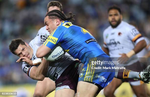 James Roberts of the Broncos is tackled by Brad Takairangi of the Eels during the round 21 NRL match between the Parramatta Eels and the Brisbane...