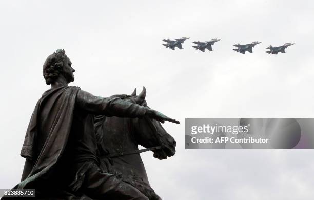 Russian fighter jets fly over the statue of Peter the Great at Senate Square in Saint Petersburg on July 28 during the Naval parade rehearsal. Naval...