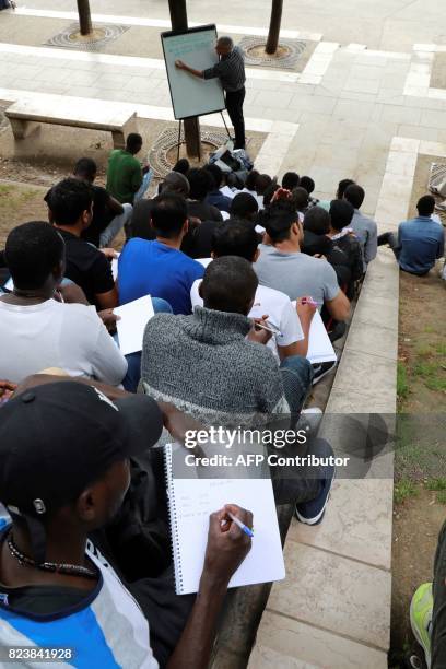 Volunteer member of the non-profit organisation Reception and Assistance office for Migrants delivers a French course at the Place de Stalingrad in...