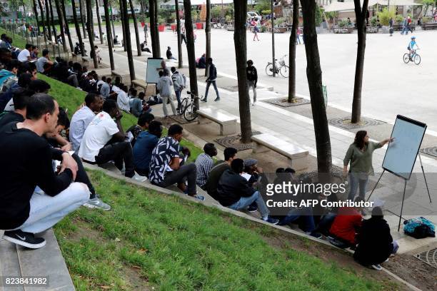 Volunteer member of the non-profit organisation Reception and Assistance office for Migrants delivers a French course at the Place de Stalingrad in...