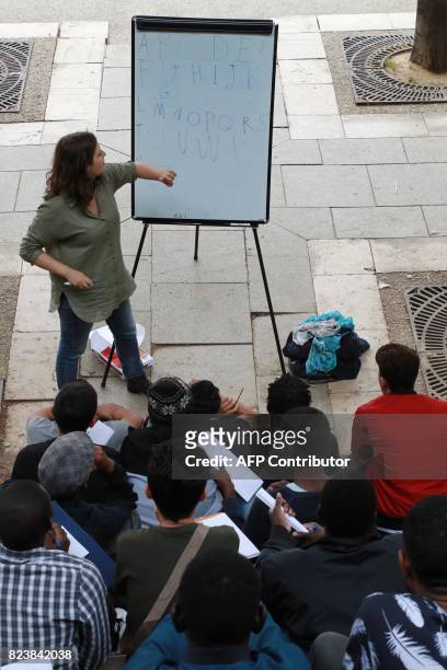Volunteer member of the non-profit organisation Reception and Assistance office for Migrants delivers a French course at the Place de Stalingrad in...