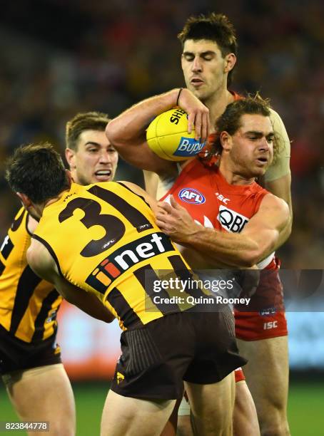 Jordan Foote of the Swans is tackled by Ricky Henderson of the Hawks during the round 19 AFL match between the Hawthorn Hawks and the Sydney Swans at...