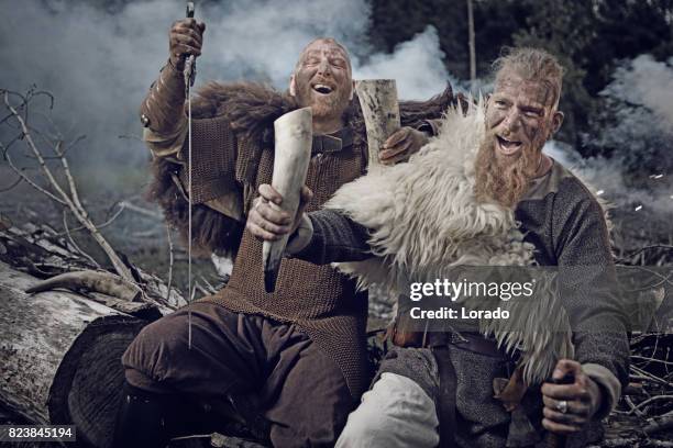 two authentic caucasian bearded viking warriors in outdoor forest setting - hunting horn stock pictures, royalty-free photos & images