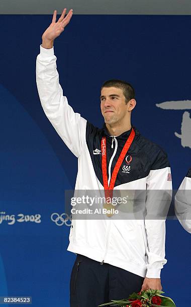 Michael Phelps of the United States waves to the crowd wearing his eighth gold medal during the medal ceremony for the Men's 4x100 Medley Relay at...