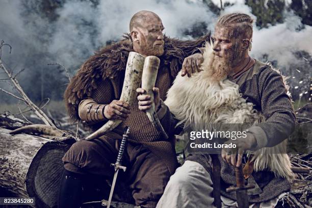 two authentic caucasian bearded viking warriors in outdoor forest setting - hunting horn stock pictures, royalty-free photos & images