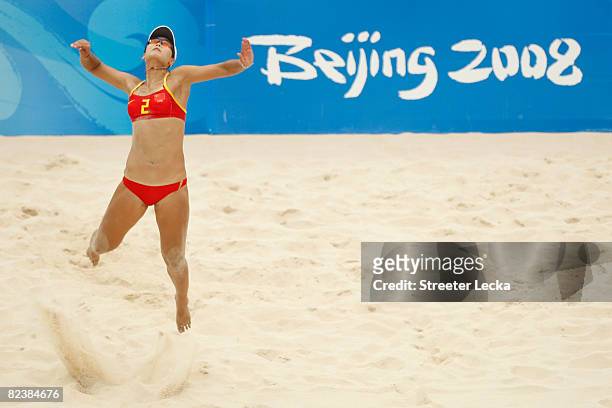 Jia Tian of China serves against Austria in the beach volleyball event held at the Chaoyang Park Beach Volleyball Ground during Day 9 of the Beijing...