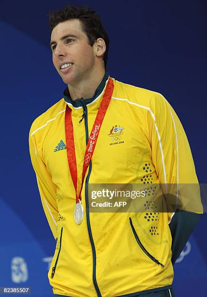 Australia's Grant Hackett stands on the podium after the men's 1500m freestyle swimming final medal ceremony at the National Aquatics Center during...