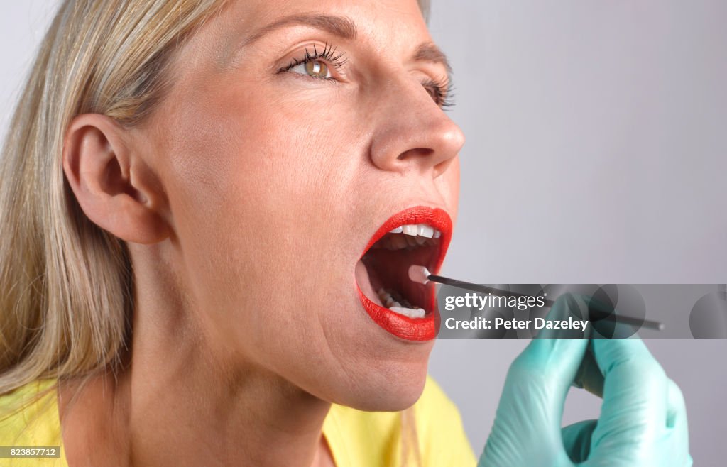 DNA TEST SWAB IN WOMAN'S MOUTH, CLOSE UP