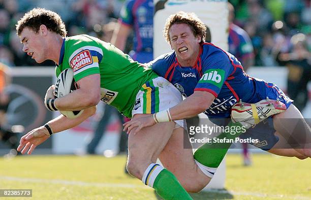 Joe Picker of the Raiders defeats the Knights defence to score a try during the round 23 NRL match between the Canberra Raiders and the Newcastle...