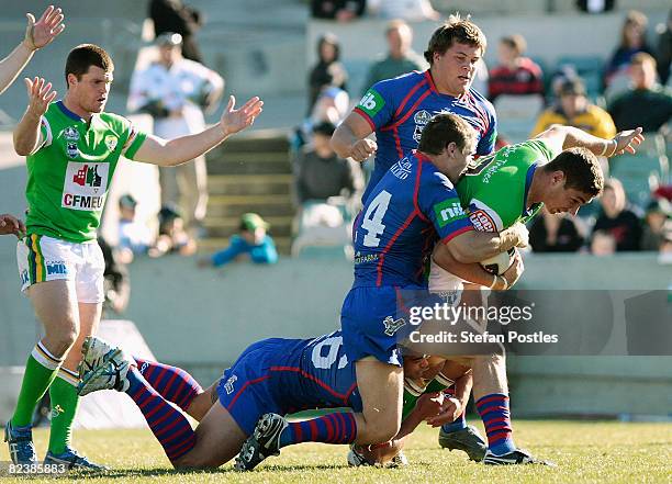 Tom Learoyd-Lahrs of the Raiders is tackled during the round 23 NRL match between the Canberra Raiders and the Newcastle Knights at Canberra Stadium...