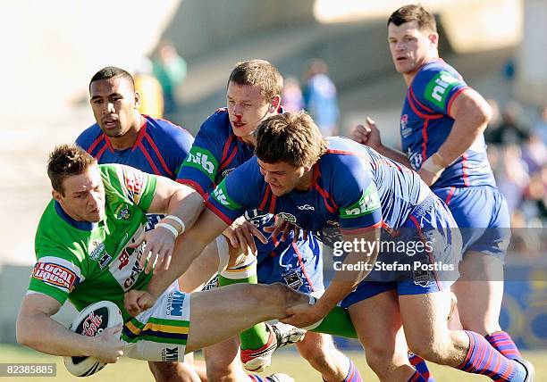 Scott Logan of the Raiders is tackled during the round 23 NRL match between the Canberra Raiders and the Newcastle Knights at Canberra Stadium on...