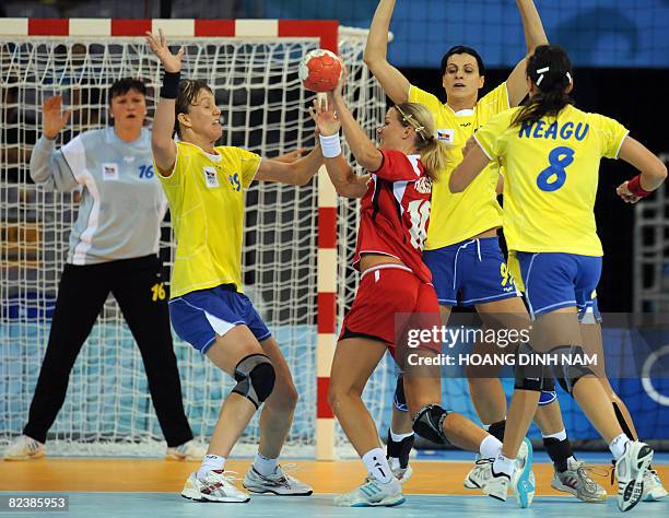 Gro Hammerseng of Norway vies for the ball with players of Romania during their Beijing 2008 Olympic Games preliminary group A handball match in...