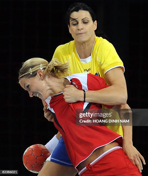 Gro Hammerseng of Norway is stopped by Gristina Georgiana Neagu of Romania during their Beijing 2008 Olympic Games preliminary group A handball match...