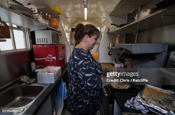 Karen, leaseholder, cooks Cumberland sausages in a frying pan inside the Kensington Park Road Cabmen's Shelter on July 27, 2017 in London, England....