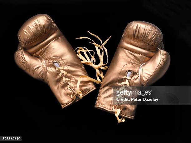 professional gold boxing gloves on black background - boxing gloves stock pictures, royalty-free photos & images