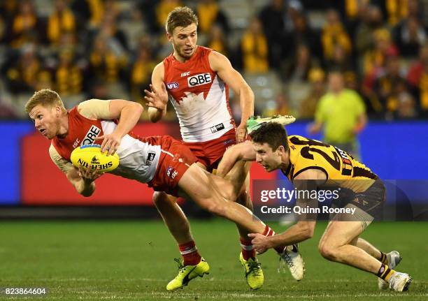 Daniel Hannebery of the Swans is tackled by Liam Shiels of the Hawks during the round 19 AFL match between the Hawthorn Hawks and the Sydney Swans at...