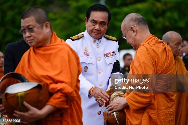 Thai Prime Minister Prayuth Chan-O-Cha gives alms to Buddhist monks to celebrate the birthday of Thai King Maha Vajiralongkorn in Bangkok, Thailand,...