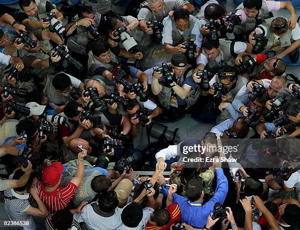 Michael Phelps of the United States greets his family, sisters Whitney and Hilary and mother Debbie, in the stands as he is surrounded by...