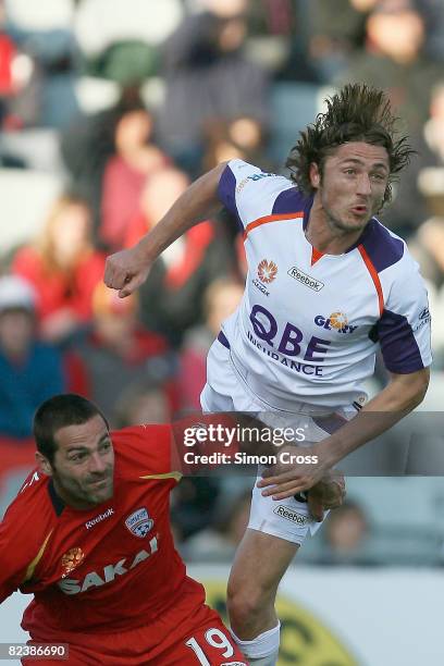 Dino Djulbic of Perth jumps over Sasa Ognenovski of Adelaide during the round one A-League match between Adelaide United and Perth Glory at Hindmarsh...