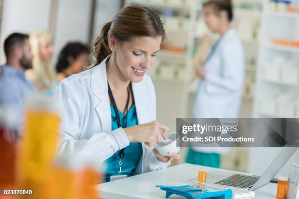 pharmacist compounds medication to fill prescription - mortar and pestle stock pictures, royalty-free photos & images