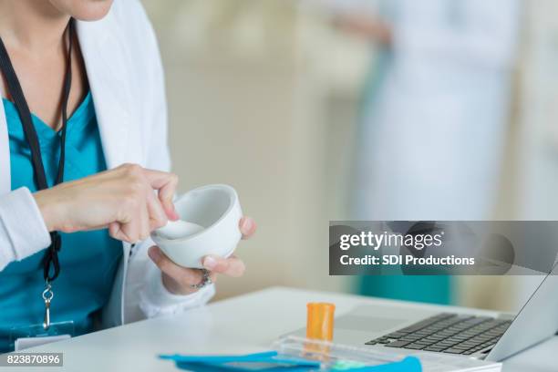 unrecognizable pharmacist uses mortar and pestle to fill prescription - pharmaceutical compounding stock pictures, royalty-free photos & images