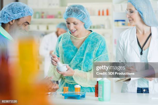 pharmacy technician mixes medication in assembly line - african mortar and pestle stock pictures, royalty-free photos & images