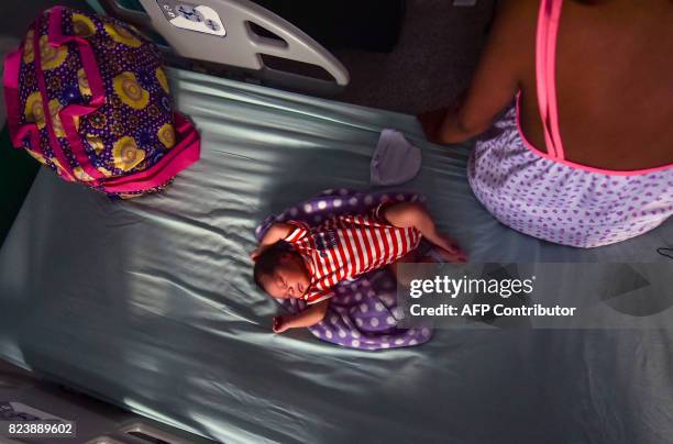 Venezuelan teenager who migrated to Colombia with a friend three years ago fleeing from her parents violence, sits next to her newborn, Juan David,...