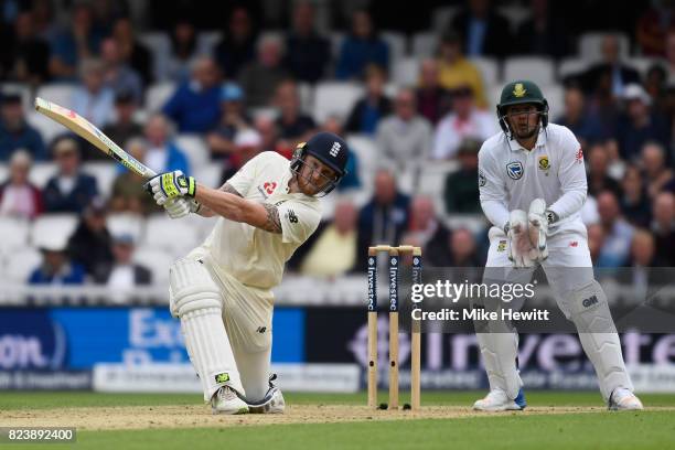 Ben Stokes of England smashes a six to bring up his century as Quinton De Kock of South Africa looks on during Day Two of the 3rd Investec Test match...