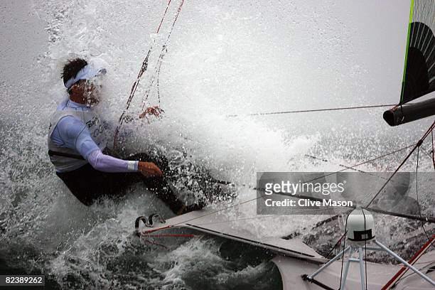 The boat of Nico Luca Marc Delle Karth and Nikolaus Resch of Austria is hit by a wave as they compete in the 49er class race held at the Qingdao...