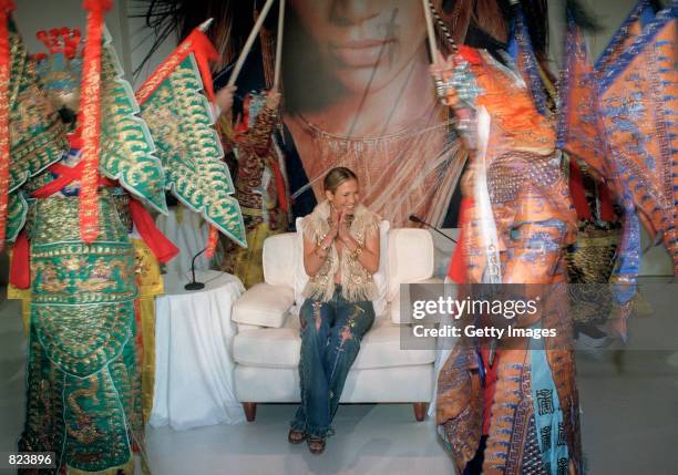 Singer and actress Jennifer Lopez applauds as she watch a Cantonese opera performance February 19, 2001 in Hong Kong during a press conference to...