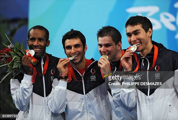 S Keeth Smart, Jason Rogers, Tim Morehouse and James Williams, celebrate on the podium after the men's team sabre gold medal match France vs. USA on...