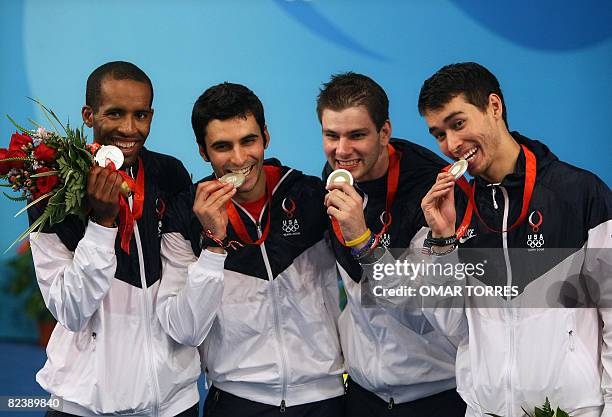 S Keeth Smart, Jason Rogers, Tim Morehouse and James Williams, celebrate on the podium after the men's team sabre gold medal match France vs. USA on...