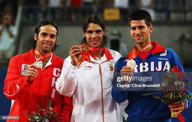 Rafael Nadal of Spain celebrates winning the gold medal with silver medalist Fernando Gonzalez of Chile and bronze medalist Novak Djokovic of Serbia...
