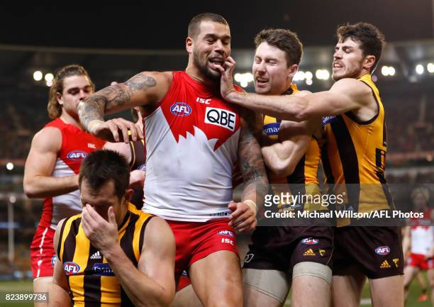 Lance Franklin of the Swans looks on as Luke Hodge of the Hawks holds his head during the 2017 AFL round 19 match between the Hawthorn Hawks and the...
