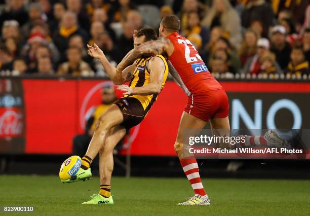 Luke Hodge of the Hawks is taken high by Lance Franklin of the Swans during the 2017 AFL round 19 match between the Hawthorn Hawks and the Sydney...