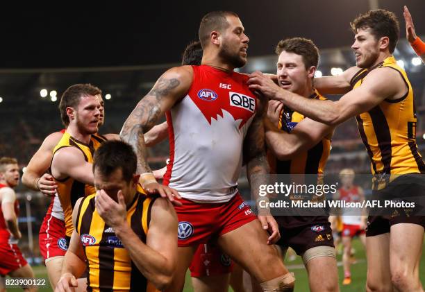 Lance Franklin of the Swans looks on as Luke Hodge of the Hawks holds his head during the 2017 AFL round 19 match between the Hawthorn Hawks and the...