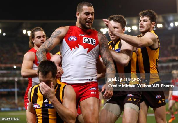 Lance Franklin of the Swans looks on as Luke Hodge of the Hawks holds his head during the 2017 AFL round 19 match between the Hawthorn Hawks and the...