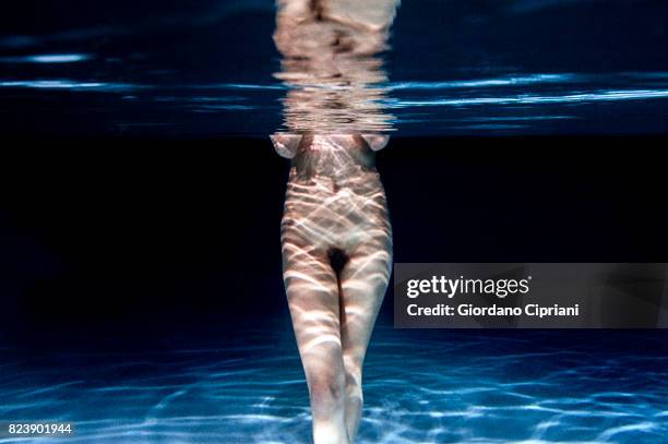 underwater image of a naked female model swimming in a pool. - underwater female models stock pictures, royalty-free photos & images