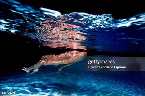 underwater image of a naked female model swimming in a pool. - underwater female models stock pictures, royalty-free photos & images