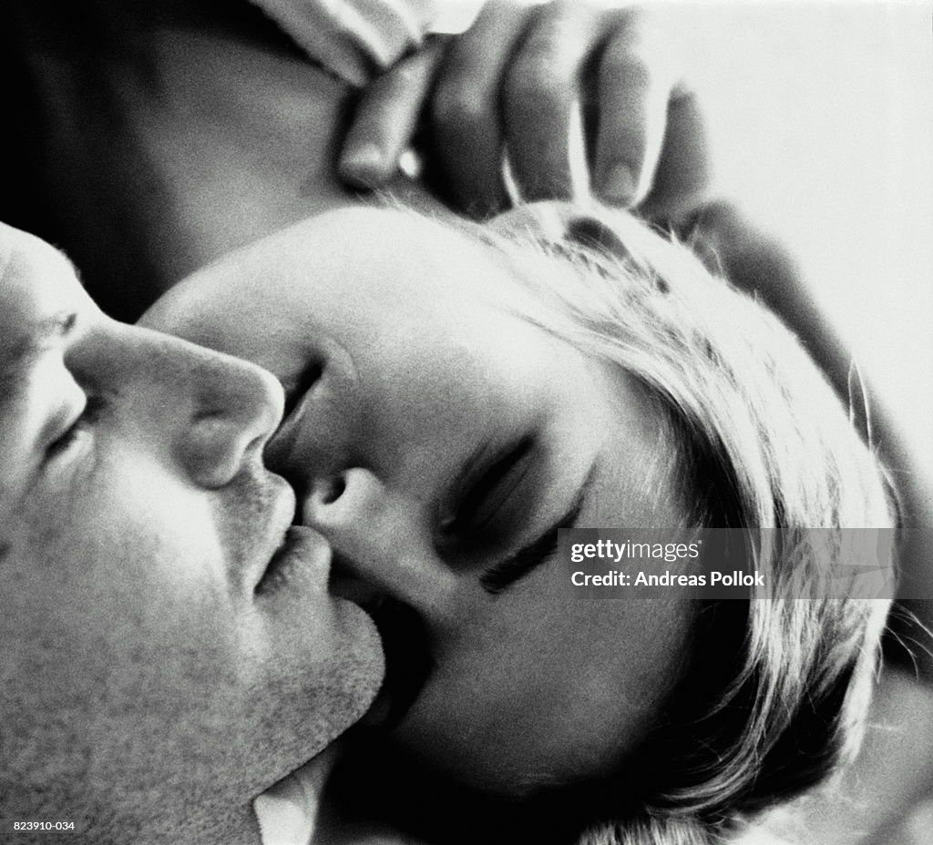 Young couple kissing, close-up (B&W)