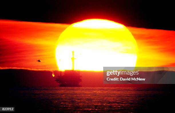 The sun sets behind the Hillhouse A oil and gas platform near the Federal Ecological Reserve in the Santa Barbara Channel, February 15 near Santa...