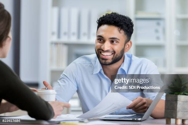 young businessman thanks assistant as she brings him coffee - handsome indian guys stock pictures, royalty-free photos & images
