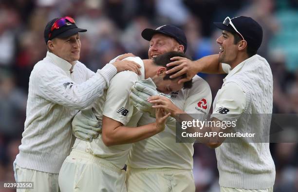 England's Toby Roland-Jones celebrates the wicket of South Africa's Hashim Amla for 6 runs with England's captain Joe Root and England's Stuart Broad...