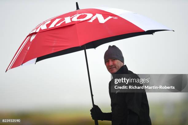 Steve Flesch of the United States looks on with an umbrella during the second round of the Senior Open Championship presented by Rolex at Royal...