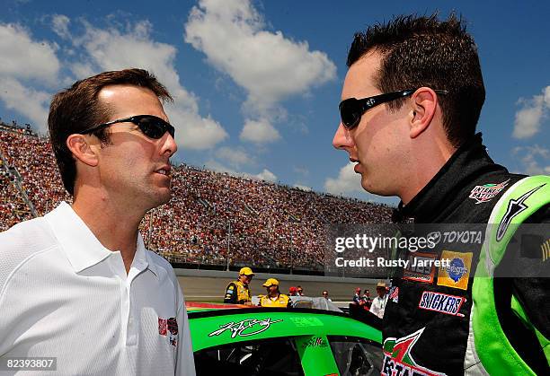 Team owner JD Gibbs speaks with his driver Kyle Busch , driver of the Interstate Batteries Toyota, on pit road prior to the start of the NASCAR...