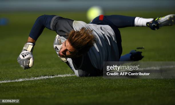 Paris Saint-Germain's German goalkeeper Kevin Trapp dives to stop a ball during a training session at the Grand Stade in Tangiers on July 28, 2017 on...